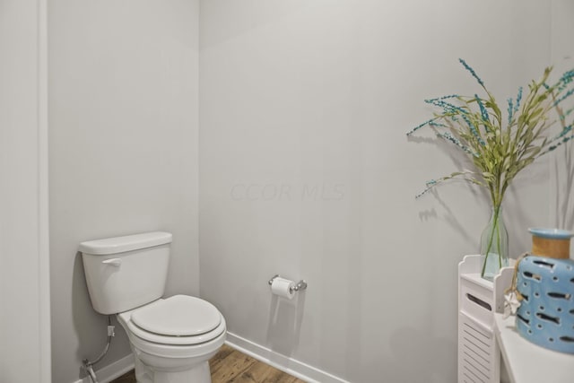 bathroom featuring hardwood / wood-style flooring and toilet