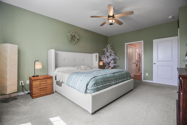 carpeted bedroom with ensuite bathroom and ceiling fan