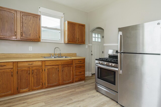 kitchen with light wood-type flooring, sink, and appliances with stainless steel finishes