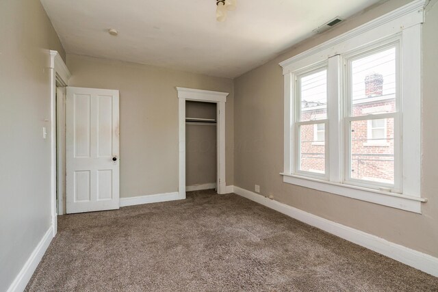 unfurnished bedroom with carpet flooring and a closet