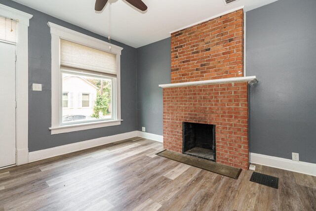 unfurnished living room with a fireplace, hardwood / wood-style floors, and ceiling fan