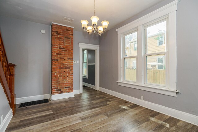 unfurnished dining area with dark hardwood / wood-style flooring and a chandelier