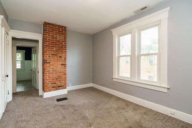 empty room with carpet flooring and a healthy amount of sunlight