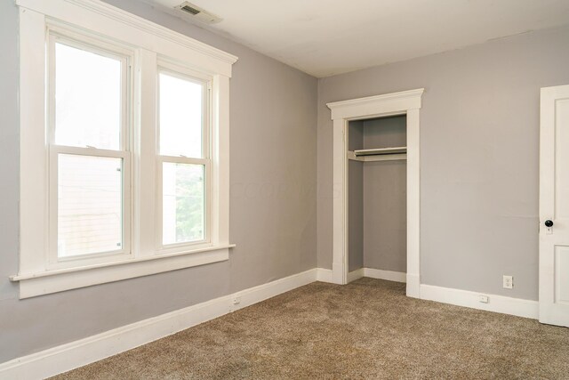 unfurnished bedroom with carpet and a closet