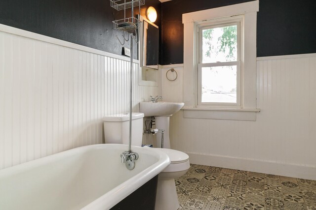 bathroom featuring a tub to relax in and toilet