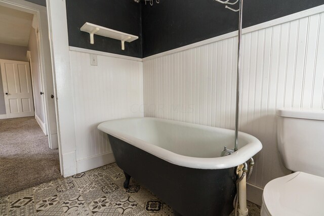 bathroom featuring a tub to relax in and toilet