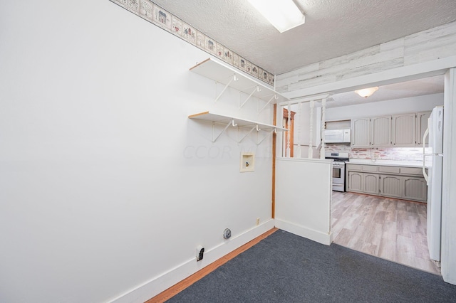 washroom with hookup for a washing machine, hardwood / wood-style floors, and a textured ceiling