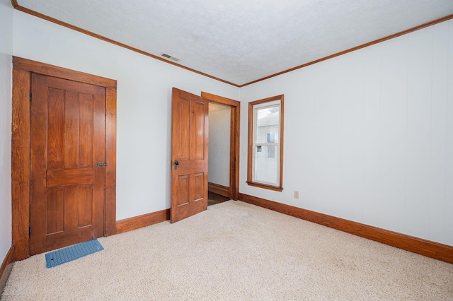 bedroom with a textured ceiling, light colored carpet, and ornamental molding