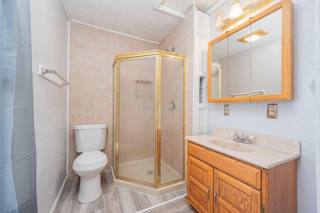 bathroom featuring vanity, toilet, wood-type flooring, and walk in shower