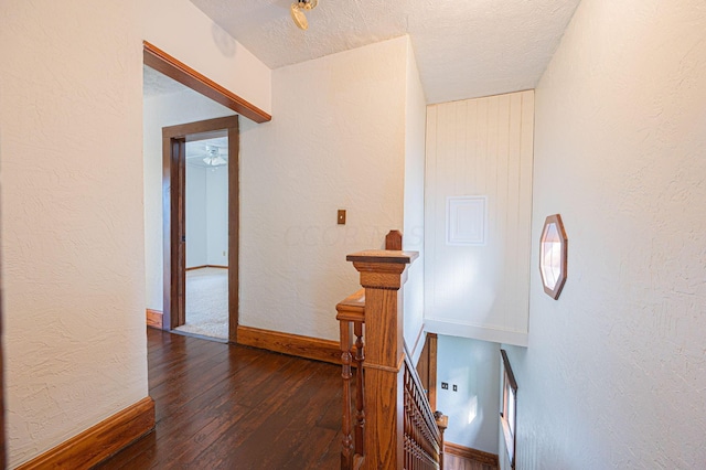 hallway featuring a textured ceiling and dark hardwood / wood-style flooring