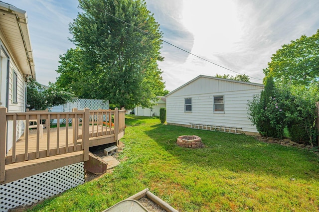 view of yard with a wooden deck and a fire pit