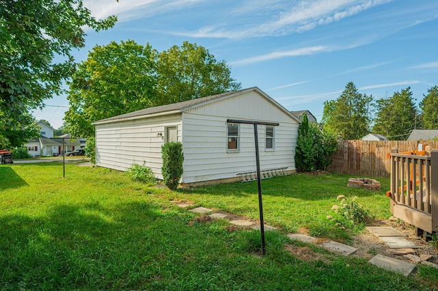 view of outbuilding with a yard and an outdoor fire pit