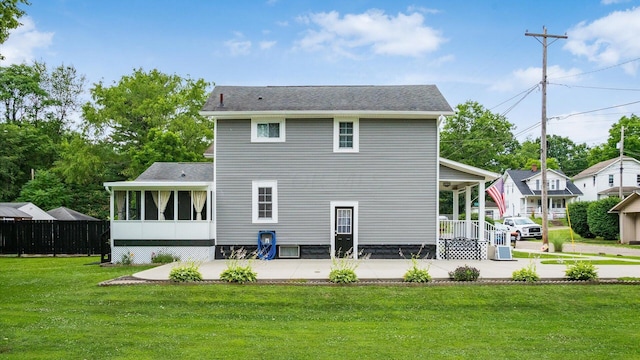 back of house with a sunroom and a yard