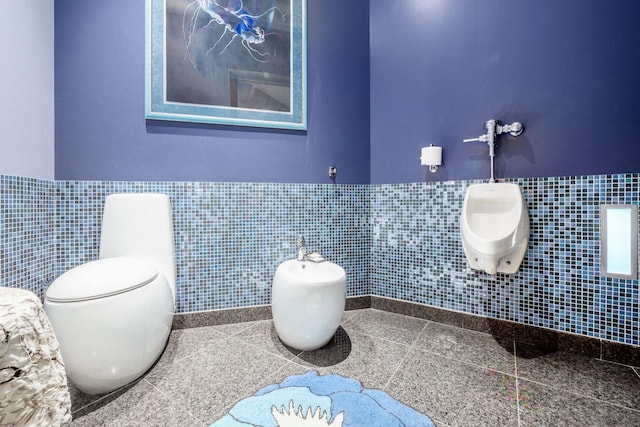 bathroom featuring toilet, tile walls, and a bidet