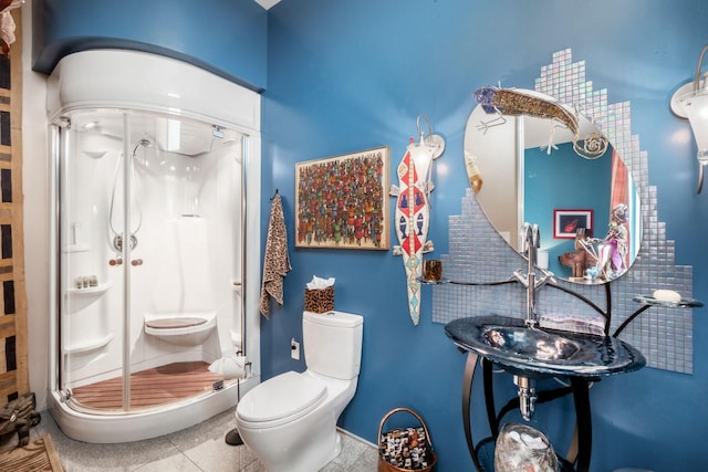 bathroom featuring tile patterned flooring, toilet, and walk in shower