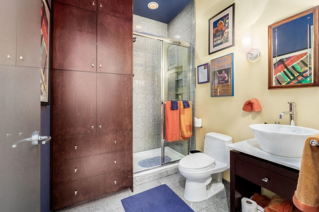 bathroom with tile patterned flooring, vanity, toilet, and a shower with door