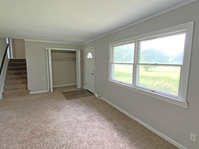 unfurnished bedroom featuring carpet, ornamental molding, and a closet