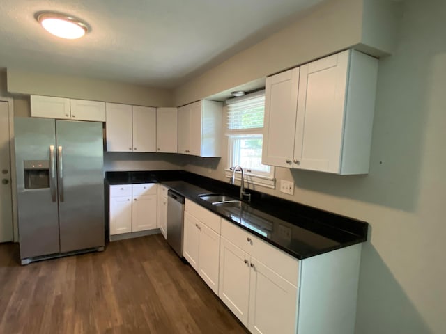 kitchen with dark hardwood / wood-style flooring, sink, white cabinetry, and stainless steel appliances