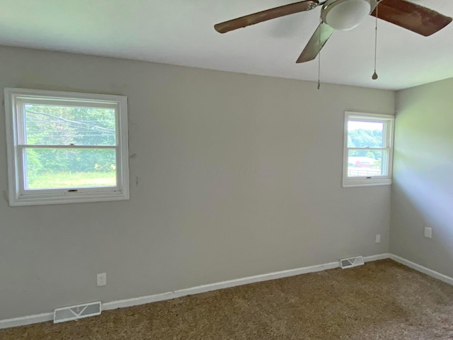 empty room featuring ceiling fan, a healthy amount of sunlight, and carpet floors