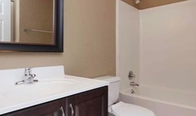 full bathroom featuring vanity, shower / bathtub combination, and toilet