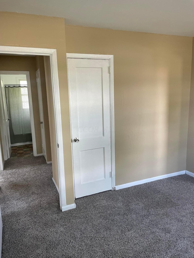 interior space with a closet and dark carpet