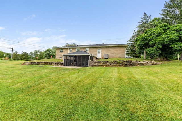 view of yard featuring central AC and a sunroom