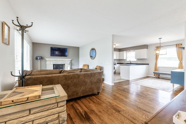 living room featuring a fireplace, dark hardwood / wood-style floors, and sink