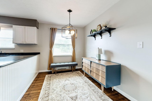 unfurnished dining area featuring dark hardwood / wood-style flooring and an inviting chandelier