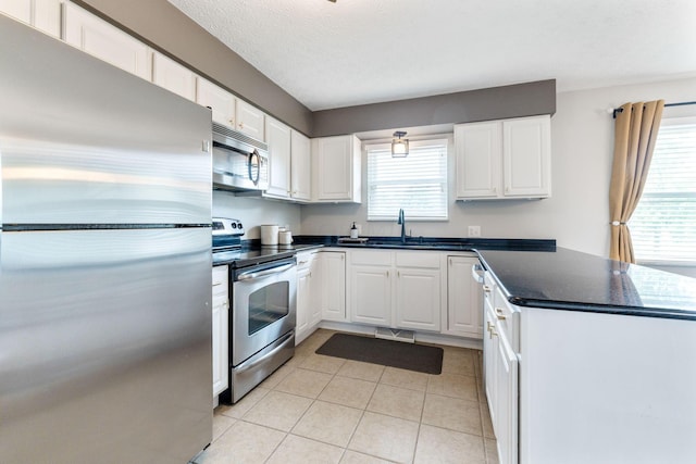 kitchen featuring white cabinets, stainless steel appliances, and a wealth of natural light