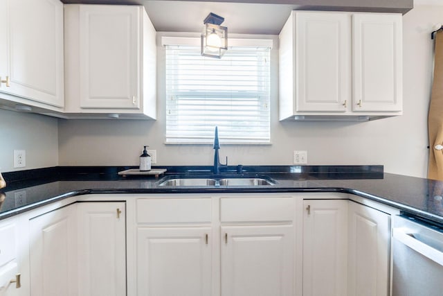 kitchen featuring stainless steel dishwasher, white cabinetry, and sink