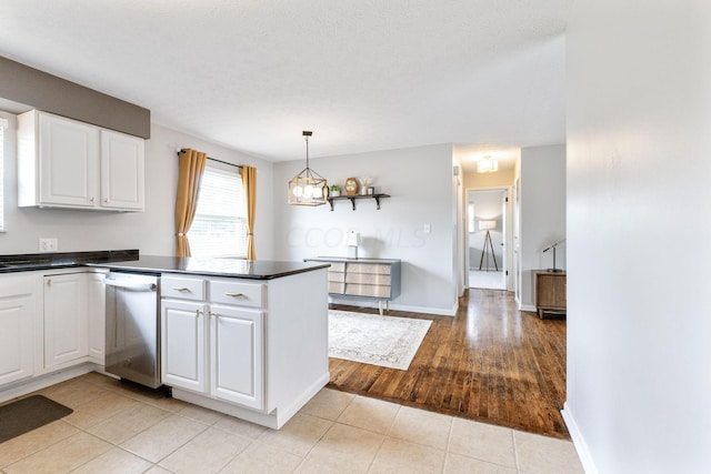 kitchen featuring white cabinetry, stainless steel dishwasher, kitchen peninsula, light hardwood / wood-style floors, and decorative light fixtures