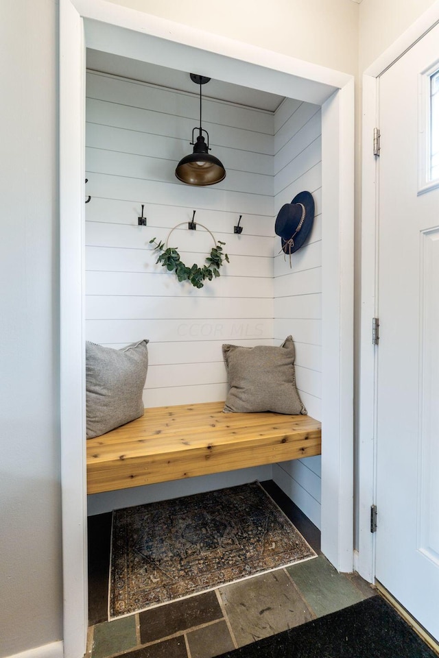 mudroom featuring wood walls