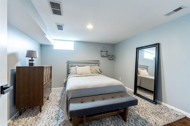 bedroom with wood-type flooring and multiple windows