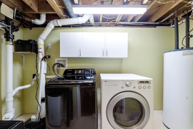 clothes washing area featuring cabinets, washing machine and clothes dryer, and water heater