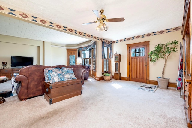 living room featuring ceiling fan, light colored carpet, and a textured ceiling