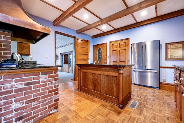 kitchen featuring stainless steel fridge, dark stone counters, light parquet floors, exhaust hood, and a kitchen island