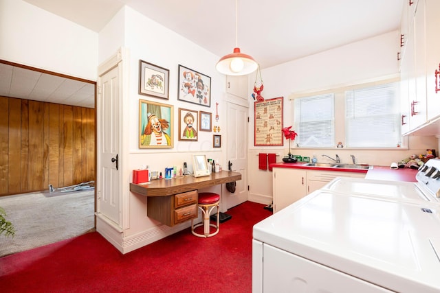 laundry area with cabinets, wooden walls, sink, dark colored carpet, and washing machine and dryer