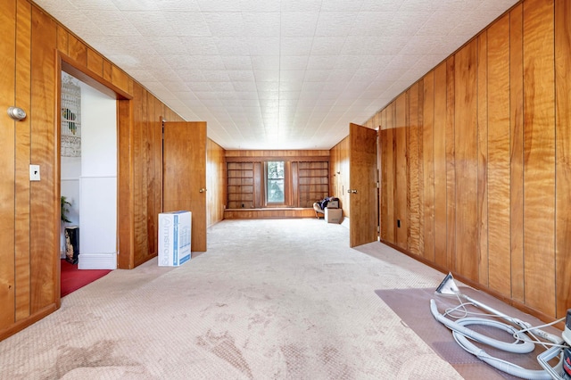 unfurnished room with wood walls and light carpet