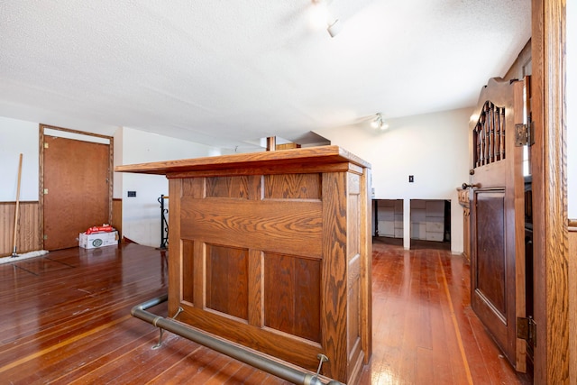 interior space with a textured ceiling and dark hardwood / wood-style flooring