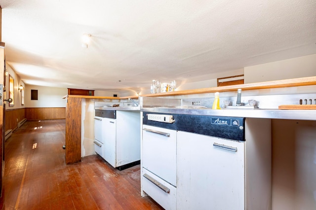 kitchen with wood walls, dark hardwood / wood-style flooring, and a textured ceiling