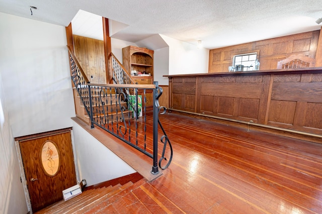 stairway featuring a textured ceiling and hardwood / wood-style flooring