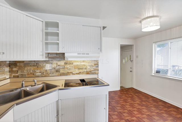 kitchen with decorative backsplash, black electric stovetop, white cabinetry, and extractor fan