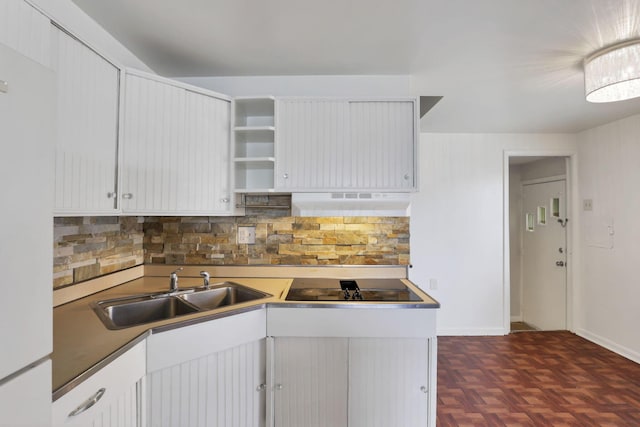 kitchen with black electric stovetop, backsplash, extractor fan, sink, and white cabinets