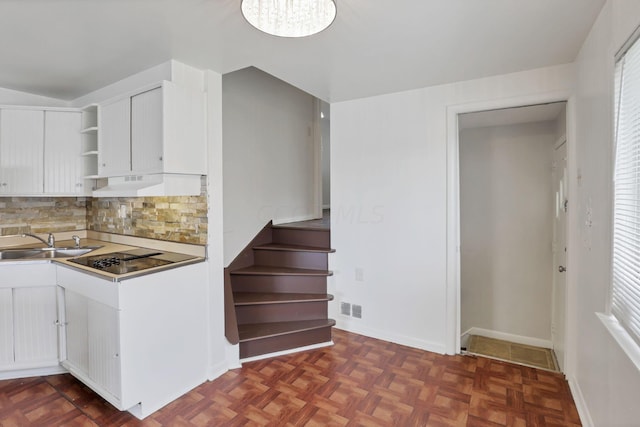 kitchen with sink, dark parquet floors, backsplash, white cabinets, and custom range hood