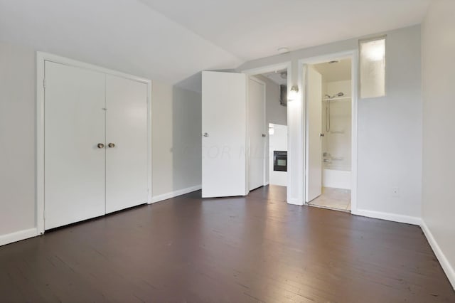 interior space featuring ensuite bathroom, dark hardwood / wood-style flooring, and a closet