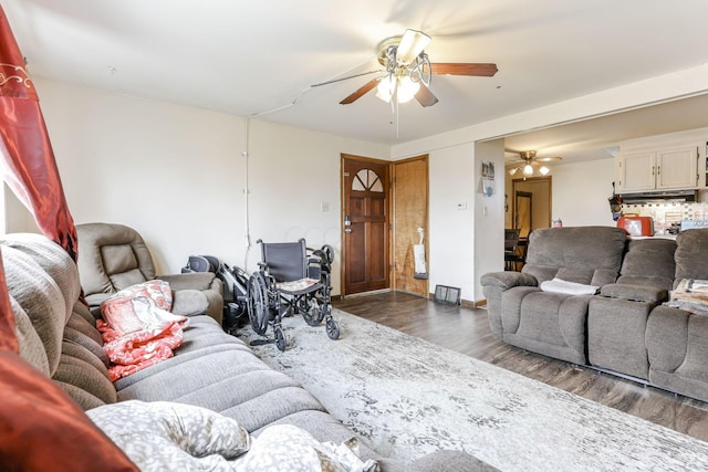 living room featuring ceiling fan and dark hardwood / wood-style flooring