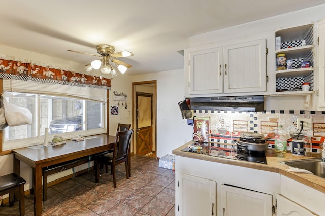 kitchen featuring tasteful backsplash, black electric cooktop, ceiling fan, sink, and white cabinetry