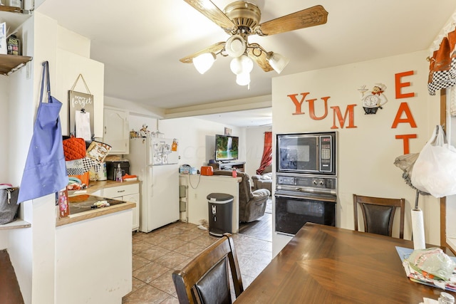 kitchen featuring white cabinetry, ceiling fan, black appliances, and light tile patterned floors