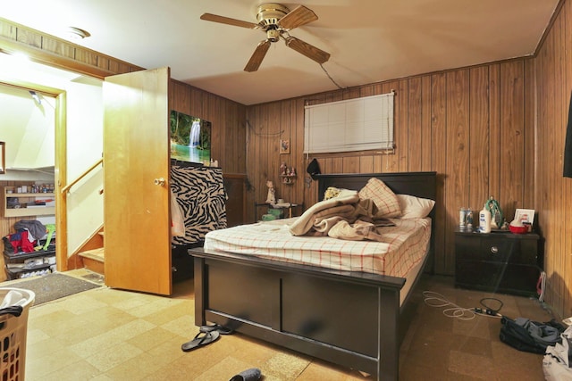 bedroom featuring wood walls and ceiling fan