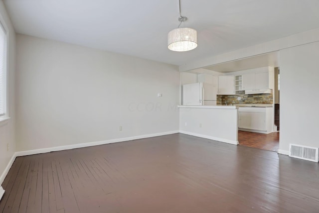 unfurnished living room with dark wood-type flooring